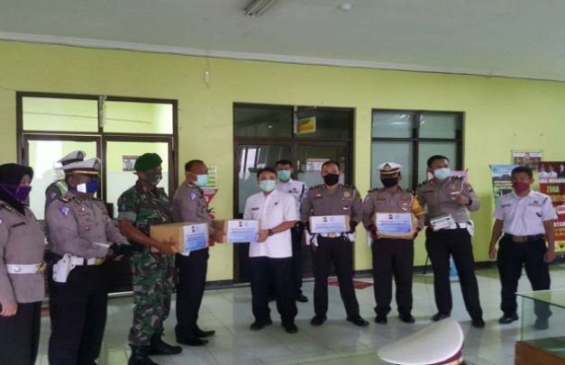 Foto: Kasat Lantas Polres Pamekasan didampingi  TNI Kodim 0826 Pamekasan dan Perwira Lantas saat memberikan bantuan APD