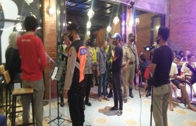 Foto : Wakapolres Sampang, Kompol Mukhamad Lutfi saat memberi himbauan dan membagikan masker kepada pengunjung cafe