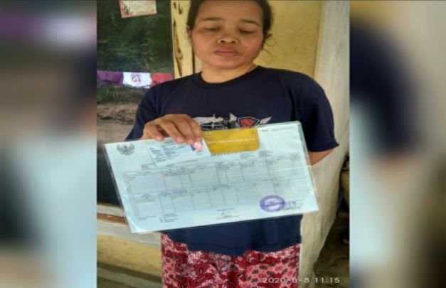 Foto: Kecewa, Saniti menunjukan kartu keluarga dan KTP, sebagai bukti 