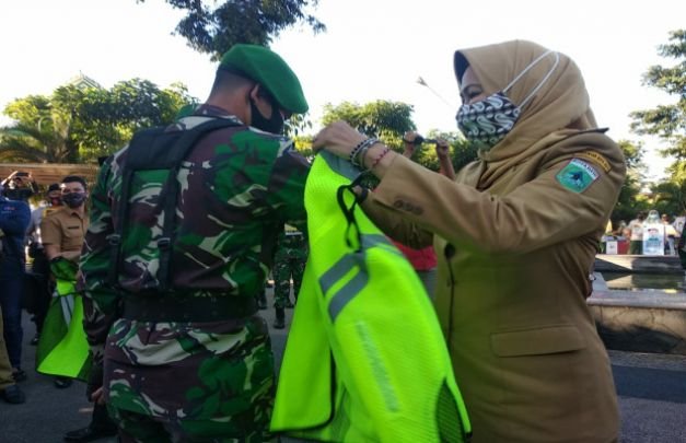 Foto: Walikota Batu Hj. Dewanti Rumpoko saat memakaikan rompi secara simbolis kepada petugas di Alun-Alun Kota Batu.