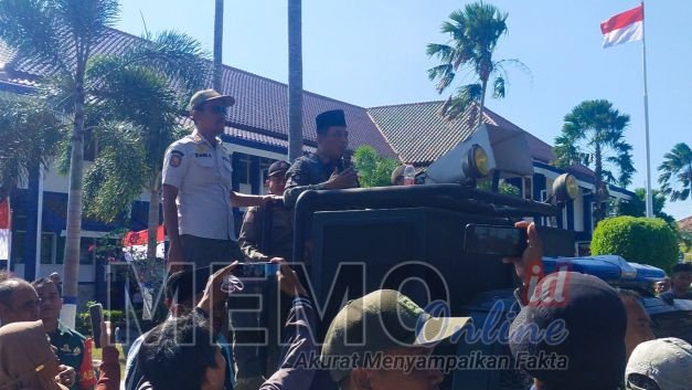Foto : Sekdakab Sampang Yuliadi Setiawan diatas mobil polisi memberikan keterangan kepada massa aksi 