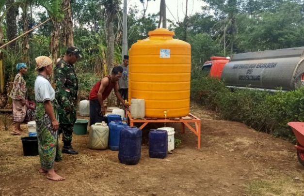 Foto: Sertu Ridwan Soqeh, saat  mendampingi warganya menerima drooping dari BPBD Lumajang