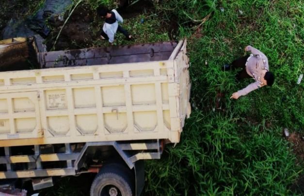 Foto: Terlihat kendaraan Dump Truck dan petugas di dasar sungai.