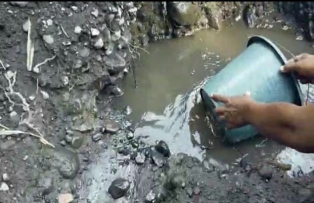 Foto: Warga menguraa air dilokasi yang diduga mengandung minyak.