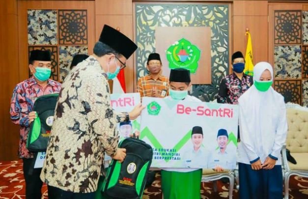 Foto: Bupati Pamekasan saat menyerahkan Beasiswa Santri kepada salah satu penerima