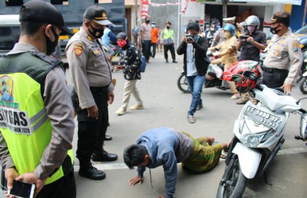 Foto : petugas saat menghukum para pelanggar Masker 
