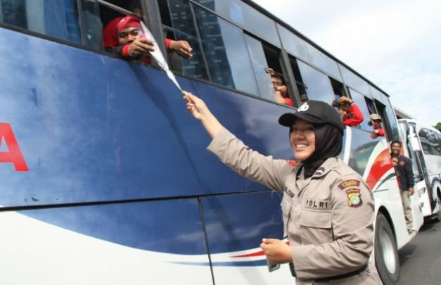 Foto: Polwan Polres Metro Jakarta Barat saat memberikan bunga pada penumpang bus