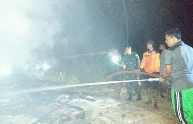 Foto: pemadam sedang menyemprotkan air ke rumah mebel yang terbakar