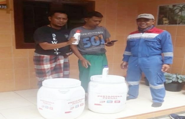 Foto: Tim dari Pertamina peduli sedang menyerahkan alat cuci tangan beserta perlengkapan lainnya kepada warga yang ada di kelurahan kota lama kecamatan Kedungkandang kota Malang