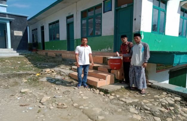 Foto : Muhammad Juhar Kepala Desa Gunung Rancak membagikan alat kelengkapan cuci tangan di lembaga pendidikan