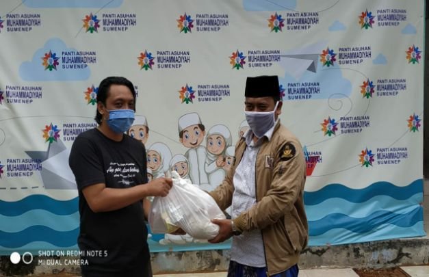 Foto: Ketua PWI Sumenep Roni Hartono saat memberikan bantuan sembako ke salah pengurus ormas islam