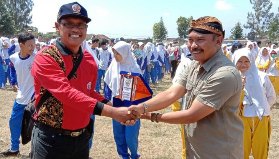 Foto: Kades Tulungrejo, Suliono (kanan) saat menyambut siswa-siswi dari SMA 7 Surabaya