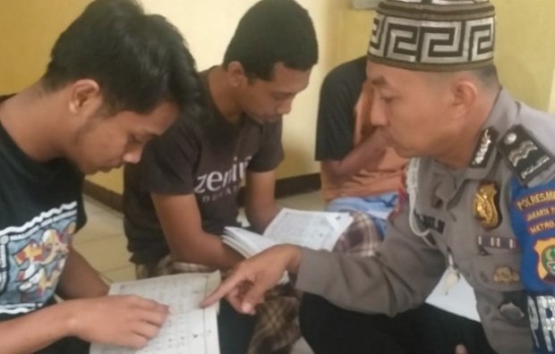 foto: Aiptu Abdul Basit saat mengajarkan tahanan membaca Ayat Suci Al Qur’an
