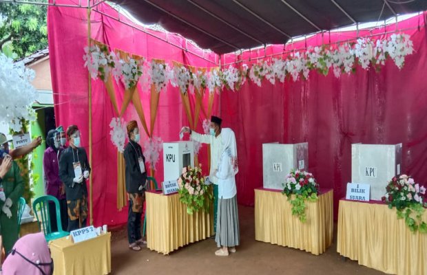 Foto : Achmad Fauzi beserta istri Nia Kurnia saat berada di TPS 003, Desa Torbang, dan melakukan pencoblosan