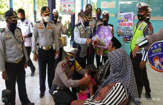 Foto: Kasatlantas Polres Pamekasan, AKP. Deddy Eka Saat Pasangkan Masker Gratis Pada Warga