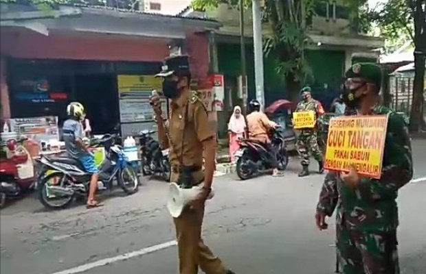 Foto: Lurah Ditotrunan, Sudarwi (membawa mega phone), bersama Serma Henry Sulistiawan.