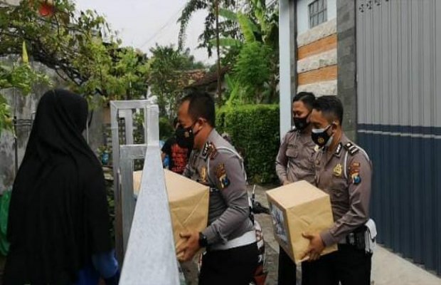 Foto: Kasat Lantas Polres Lumajang AKP I Putu Angga Feriyana membawa paket santunan dan menyerahkan motor korban laka