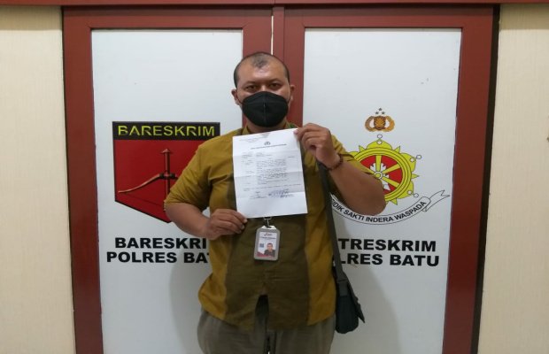 Foto: Yiyin Lukman Adiwinoto, saat menunjukkan surat tanda penerimaan laporan dari Satreskrim Polres Batu.