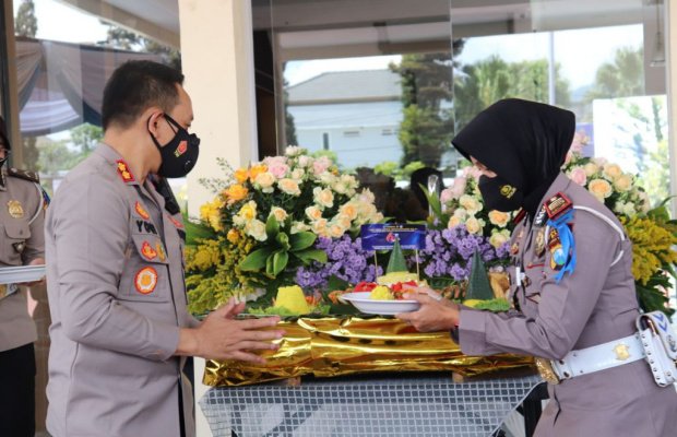 Foto : Kapolres saat memberikan potongan tumpeng kepada Kasatlantas Polres Batu.