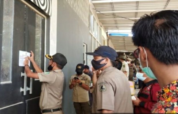 Foto: Petugas gabungan saat melakukan penutupan kafe Apoeng Kheta di Jalan Raya Sumenep