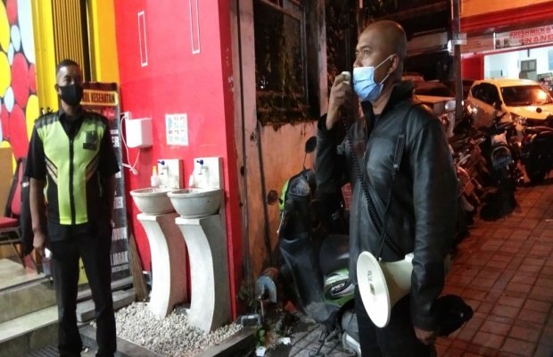 Foto: Kanit Regident Satlantas Polres Batu saat menghimbau agar rumah makan dan tempat hiburan ditutup pada pukul 22.00 WIB.