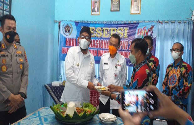 Foto: Bupati Sumenep Ach. Fauzi, saat memberikan potongan tumpeng kepada Ketua PWI Sumenep