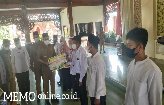  Foto : Bupati Pamekasan, Baddrut Tamam Saat Serahkan Honor Guru Secara Simbolis.