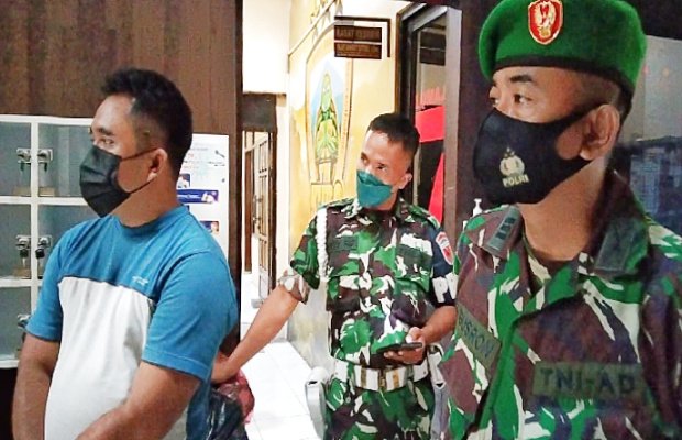 Foto : Pria inisial 'P' yang mengaku anggota BAIS TNI (depan) didampingi anggota CPM setibanya di ruang Satreskrim Polres Lumajang.