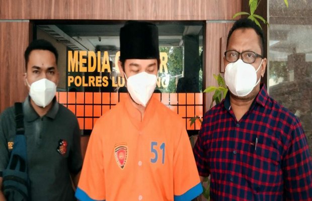 Foto : tersangka HF (tengah) diapit petugas