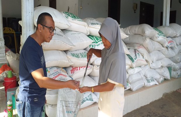 Foto: Ibnu Hajar saat mengecek kualitas beras di rumah Sugiyati di Desa Baban Gapura