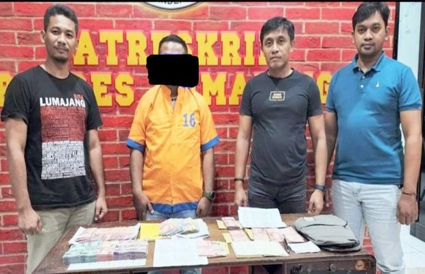 Foto : Tersangka dan barang bukti uang tunai di atas meja diapit petugas