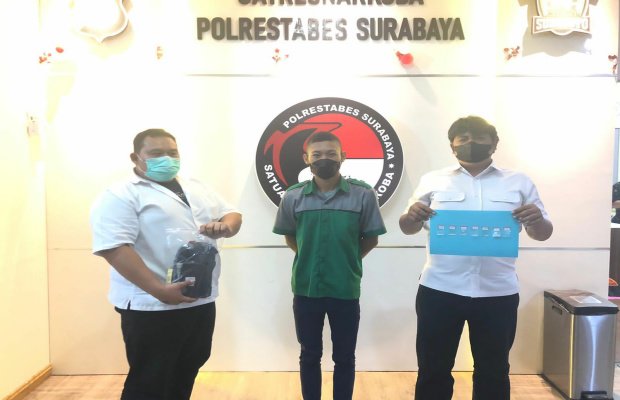 Foto: Tersangka (tengah) bersama barang buktinya diapit oleh dua petugas di Polrestabes Surabaya 