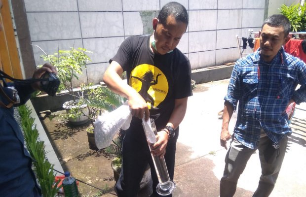 Foto: Petugas SPBU Kalisat ambil air untuk sempel