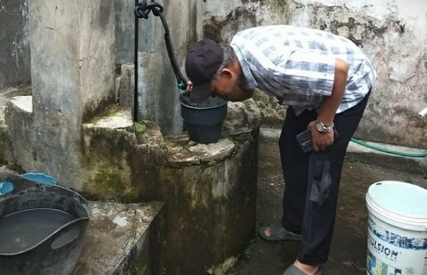 Foto: Kepala sekolah SDN 1 Glagahwero saat cium air yang diduga tercemar limbah 