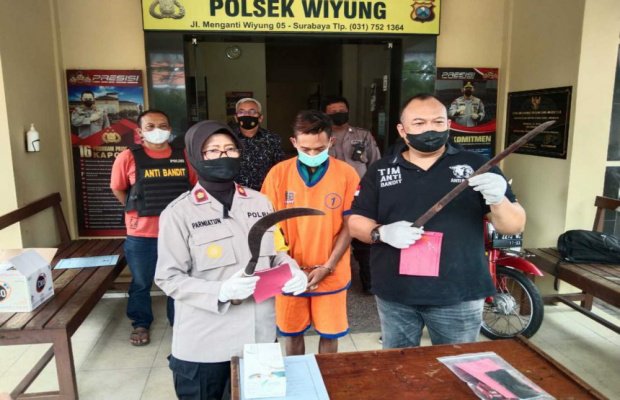 Foto: tersangka ditengah diapit dua orang petugas, Kapolsek Wiyung dan Kanitnya