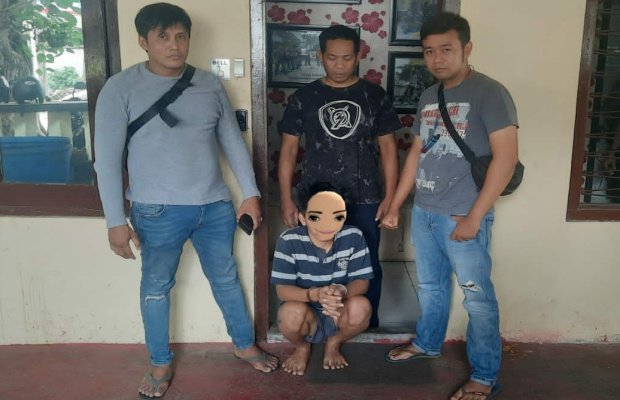 Foto : tersangka ditengah berikut barang buktinya saat diamankan petugas Kepolsek Tegalsari Surabaya.