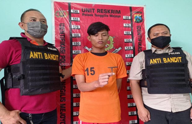 Foto: tersangka ditengah dengan diapit dua petugas tim bandit polsek tenggilis Surabaya 