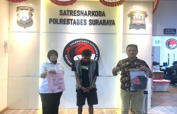 foto: tersangka Ditengah diapit dua petugas sambil menunjukan barang buktinya 