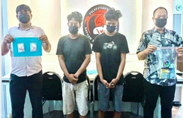 Foto: Tersangka di apit dua petugas dengan  barang buktinya 