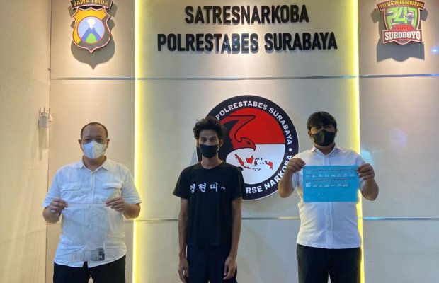 Foto: tersangka ditengah diapit dua petugas dari narkoba Polrestabes Surabaya