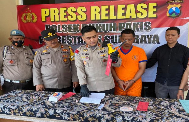 Foto: tersangka ditengah diapit Kapolsek Dukuh Pakis bersama anggotanya