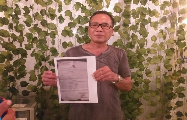 Foto: Anas Marsis saat menunjukan surat laporan Magdhalena dari Polrestabes Surabaya 