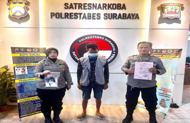 Foto: tersangka ditengah diapit dua petugas dari Resnarkoba Polrestabes Surabaya