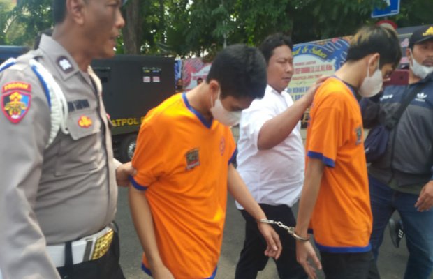 Foto: Tersangka saat dipamerkan oleh Polrestabes Surabaya bersama barang buktinya 