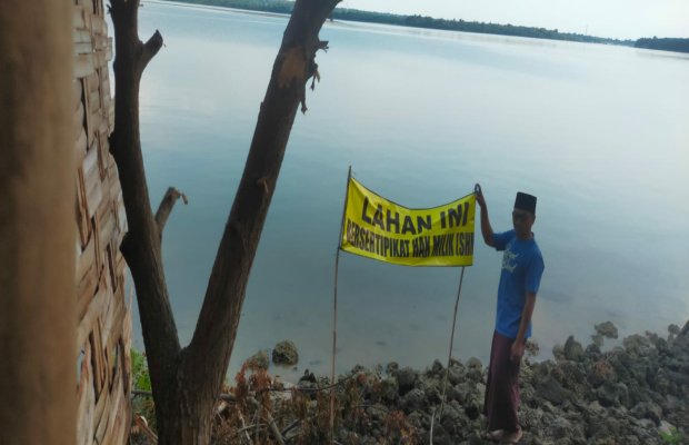 Foto: Salah seorang warga menunjuk sempadan pantai yang sudah dibubuhi tanda 'tanah milik pribadi'
