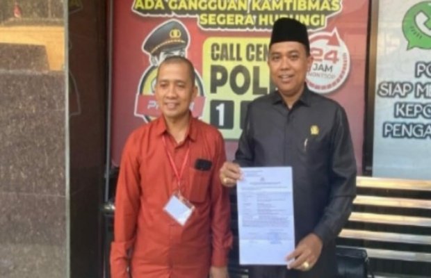 Foto : H. Akhmat S.T menunjukkan surat bukti lapor polisi