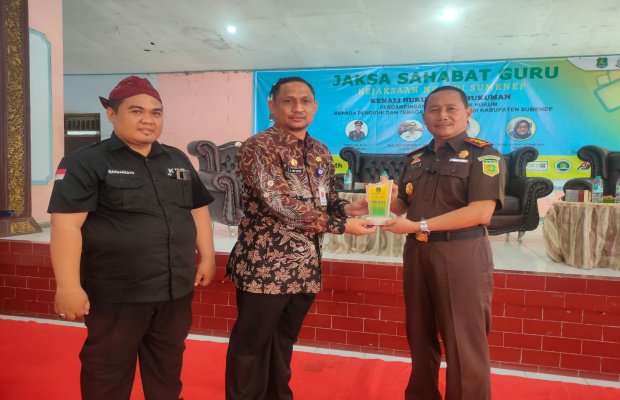 Foto: Kajari Sumenep Trimo, SH.MH. saat menyerahkan cendra mata kepada Kadisdik Sumenep