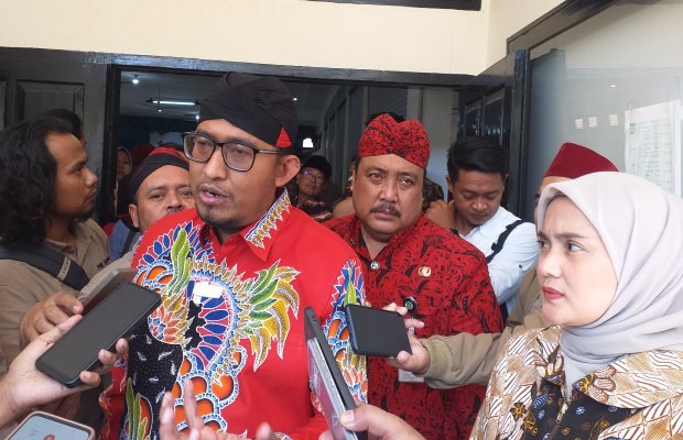 Foto: Mengenakan Blangkon Merah, Kadinsos P3A Sumenep Drs Achmad Dzulkarnaen berada dibelakang Bupati Fauzi