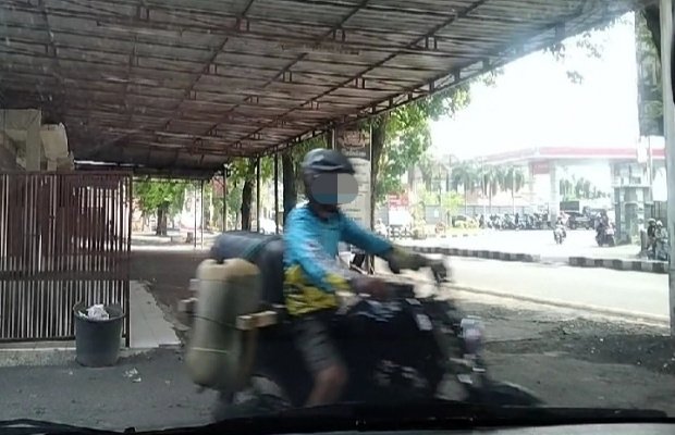 Foto: Salah seorang tengkulak tertangkap kamera seusai dari SPBU Sukodono (seberang jalan)