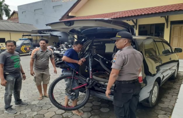 Foto: Tersangka saat reka ulang menaijjan sepeda angin hasil curiannya ke mobil 